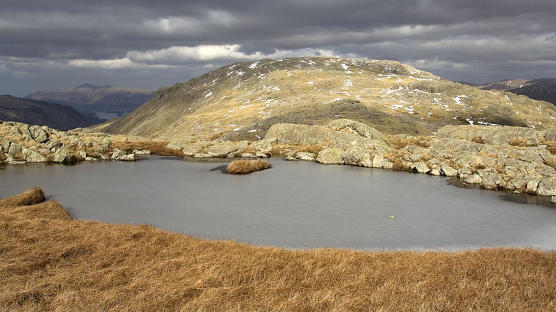 A shaft of sun highlights a frozen pool near Allen Crags A shaft of sun highlights a frozen pool near Allen Crags